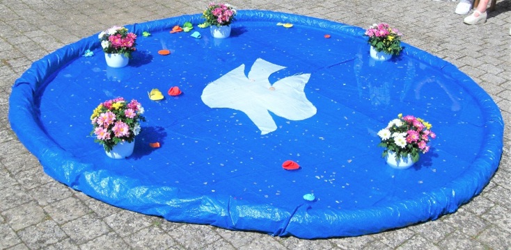 Die Wasserfläche zierte ein Taubenbild in der Mitte. Die Tauffamilie hatte zudem blühende Blumen hineingestellt. Foto: Manfred Hund Die Wasserfläche zierte ein Taubenbild in der Mitte. Die Tauffamilie hatte zudem blühende Blumen hineingestellt. Foto: Manfred Hund